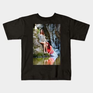 Two beautiful young women leaning on rocks beside a river Kids T-Shirt